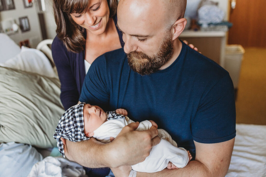 Tiny Toes Photography STL Newborn and Motherhood Photographer new mom and dad holding their newborn in the hospital 